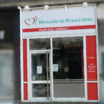 Devanture de l’agence de Rive-de-Gier. On y distingue une porte d'entrée ainsi que le logo affiché en haut de l'agence. Les entreprises à coté son floutée !